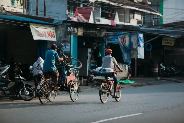 a couple of people riding bikes down a street